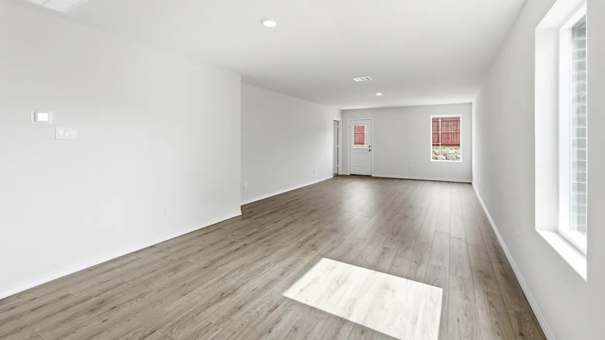 Spacious room featuring wood-finish flooring, recessed ceiling lighting, and white walls