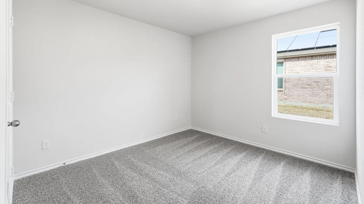 Neutral wall paint, gray carpet flooring, white trim, and a white-framed window
