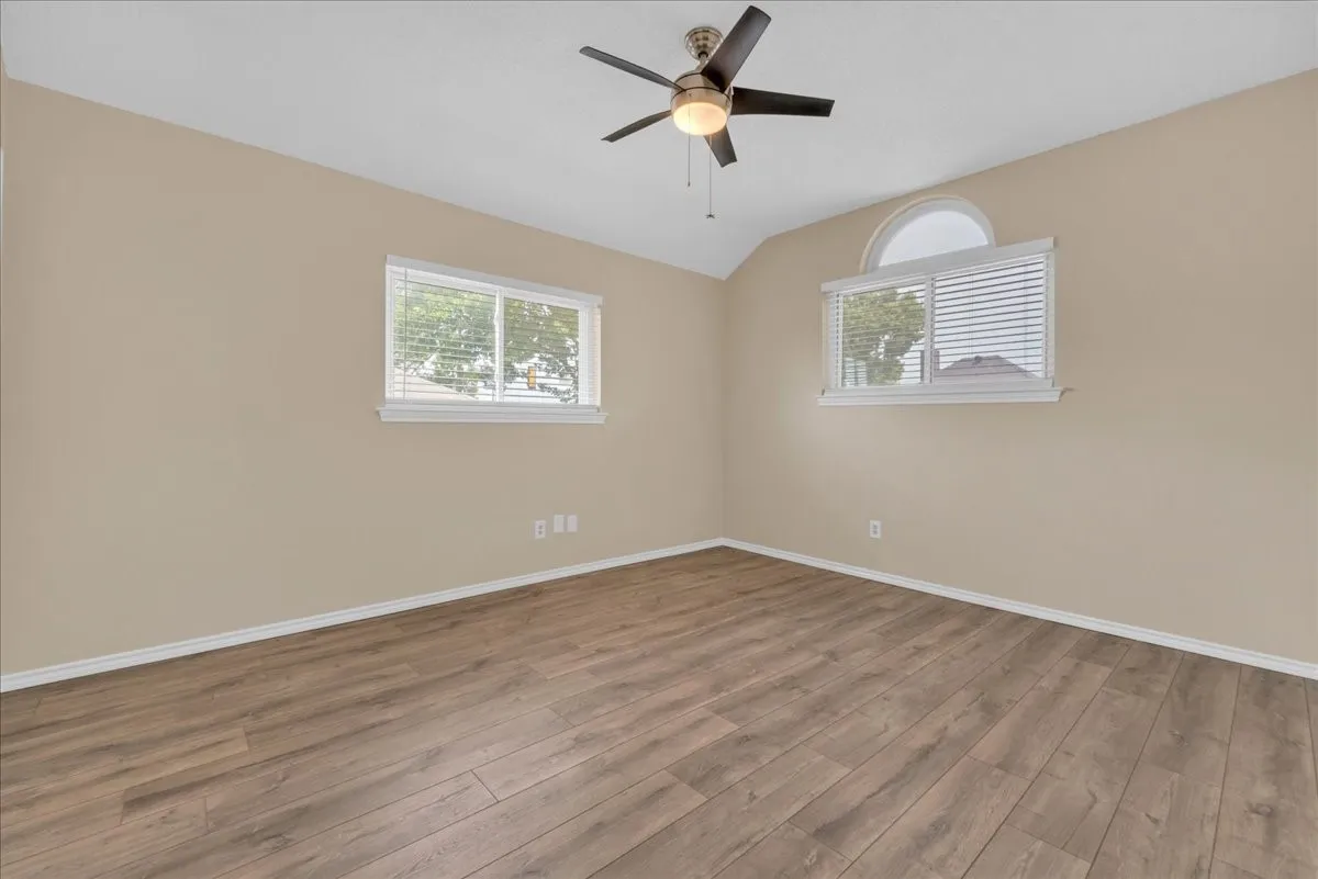 Wood-finish flooring with neutral wall tones and a ceiling fan