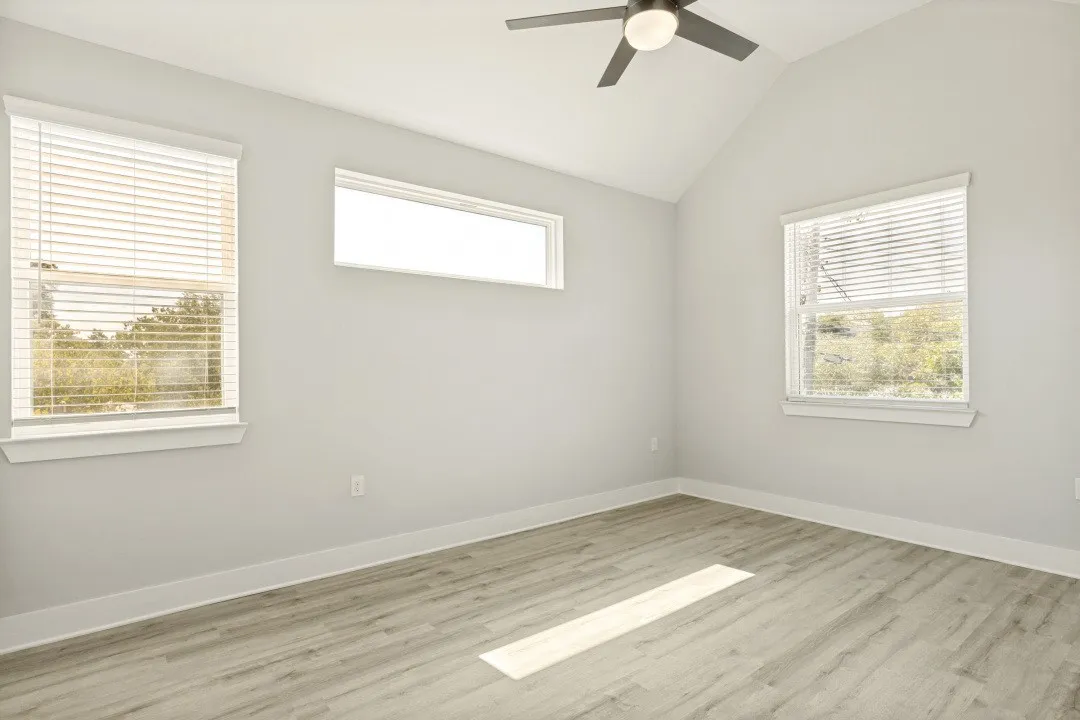 Wood-finish flooring, vaulted ceiling, and ceiling fan with integrated lighting