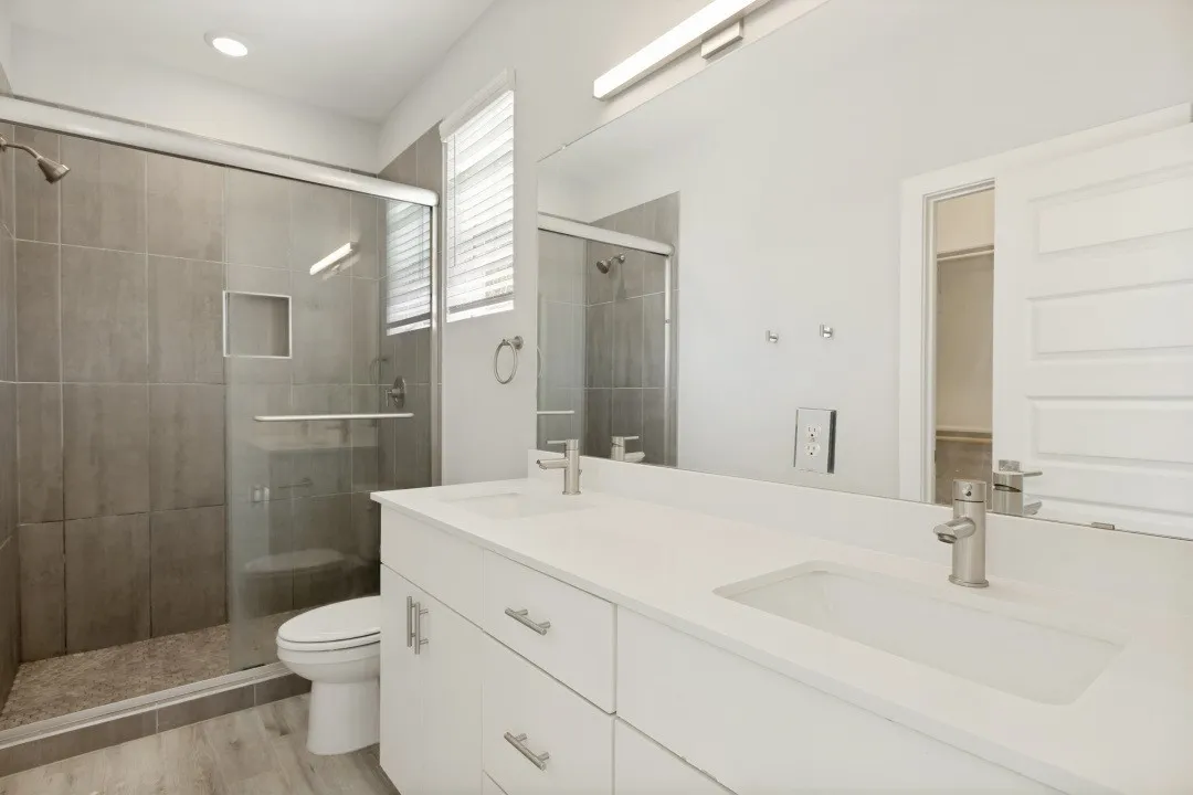 Dual vanity with integrated sinks, quartz countertop, and brushed nickel fixtures