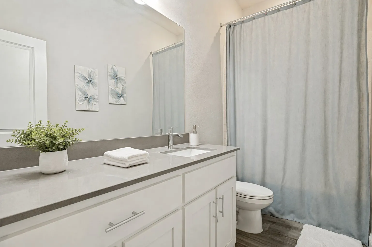 **Virtually staged for effect**White vanity with brushed nickel pulls, integrated rectangular sink, and gray stone-finish countertop