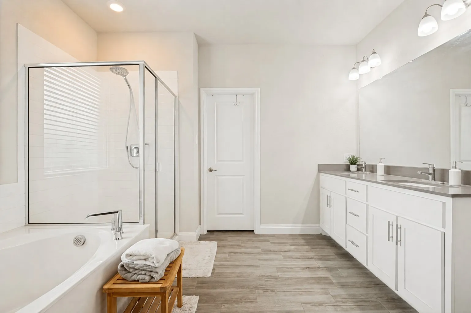 **Virtually staged for effect**Spacious bathroom featuring a glass-enclosed shower, a separate soaking tub with deck-mounted faucet, and a dual vanity with undermount sinks and a large mirror