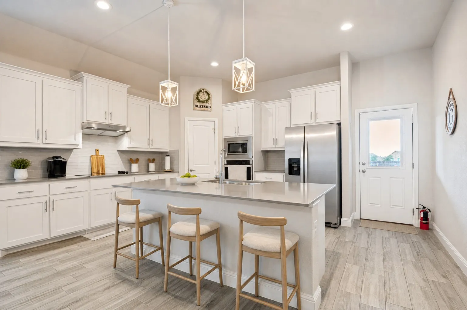 **Virtually staged for effect**Kitchen featuring wood-finish flooring, recessed lighting, a built-in microwave, stainless steel appliances, and a kitchen island with a basin sink