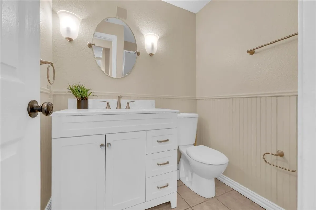 White vanity with a solid surface countertop, an undermount sink, and brushed nickel hardware