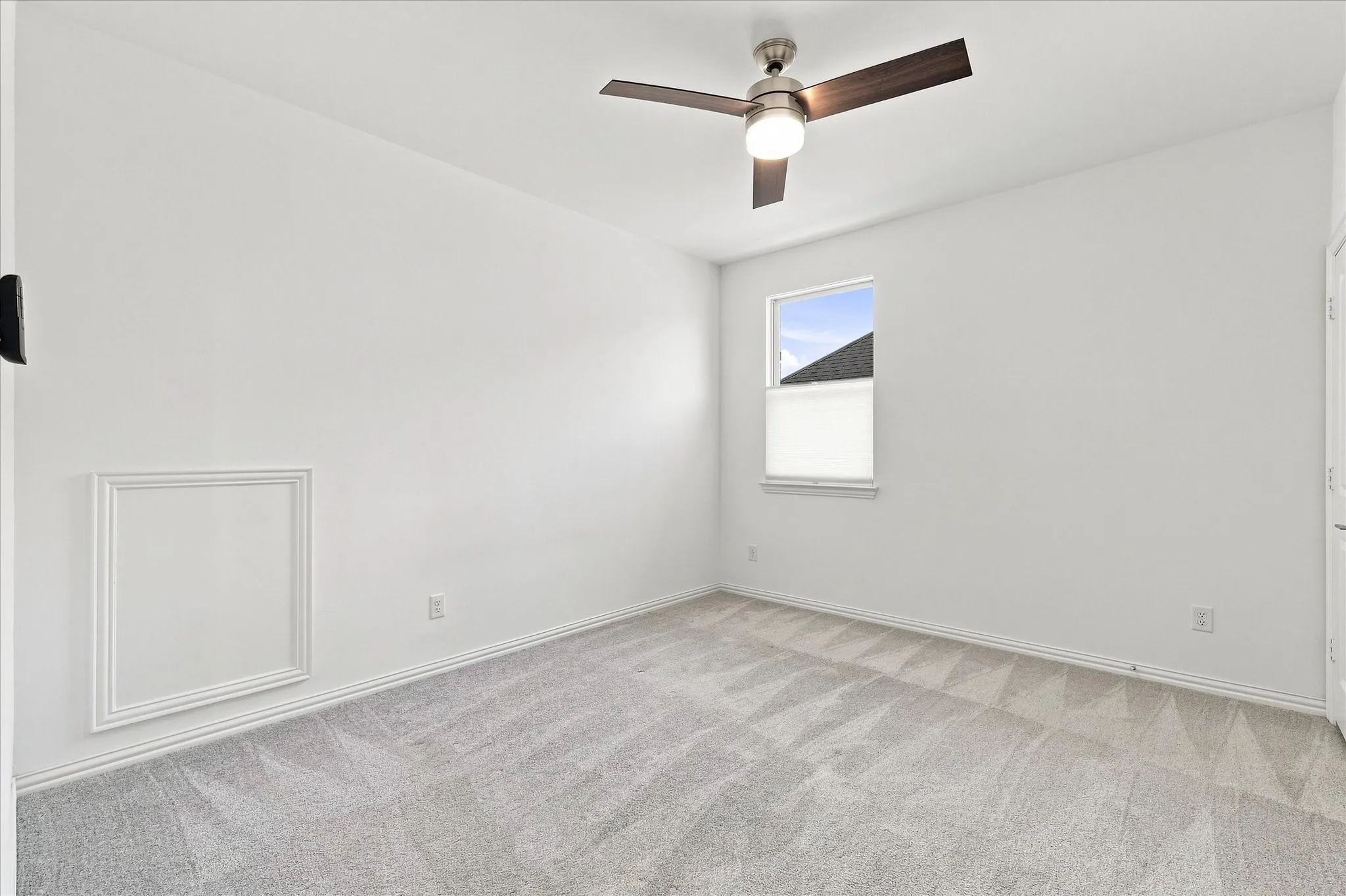Carpeted flooring with a ceiling fan, white walls, and a window