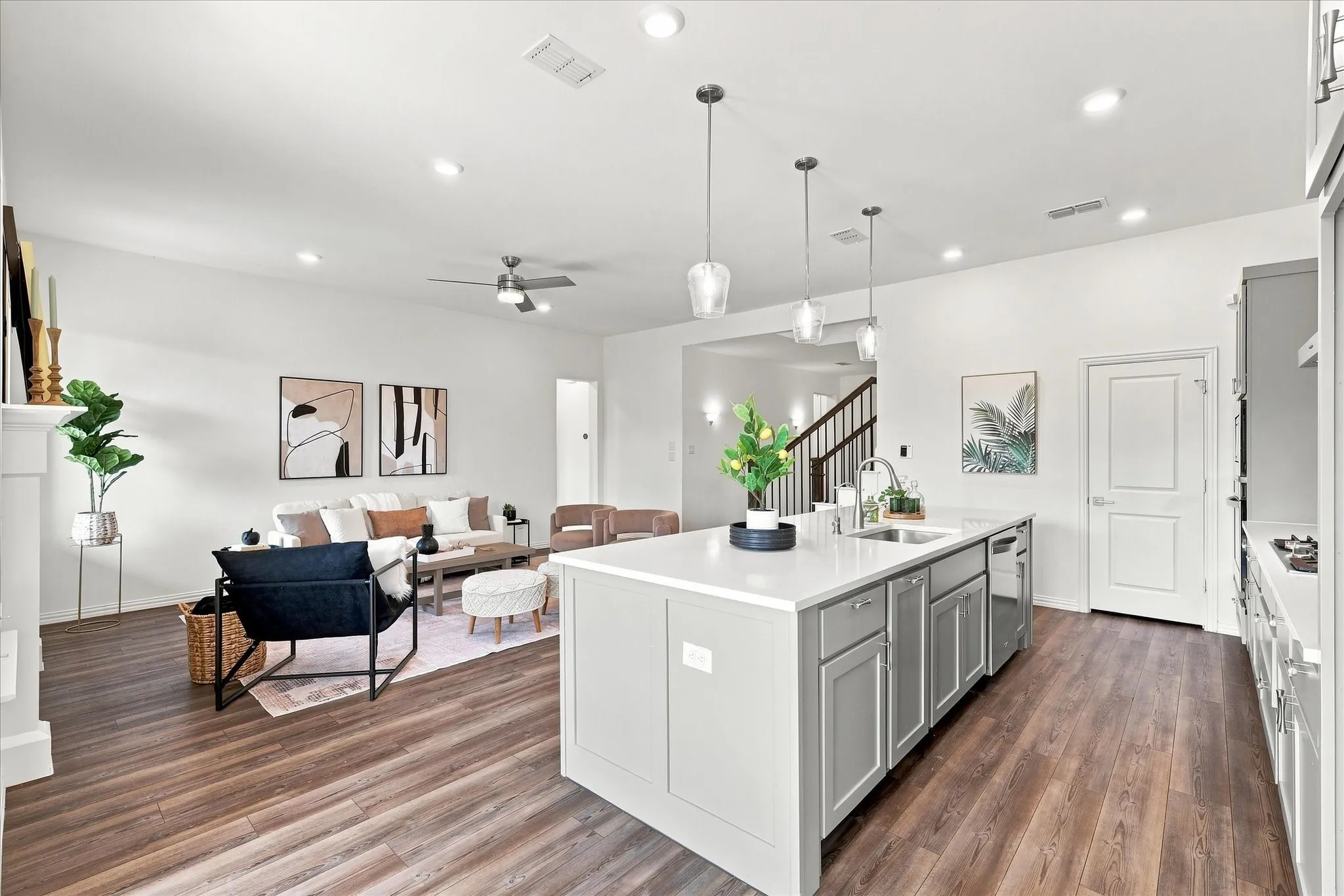 Open-concept kitchen and living area featuring wood-finish flooring, recessed lighting, a ceiling fan, and a kitchen island with pendant lighting