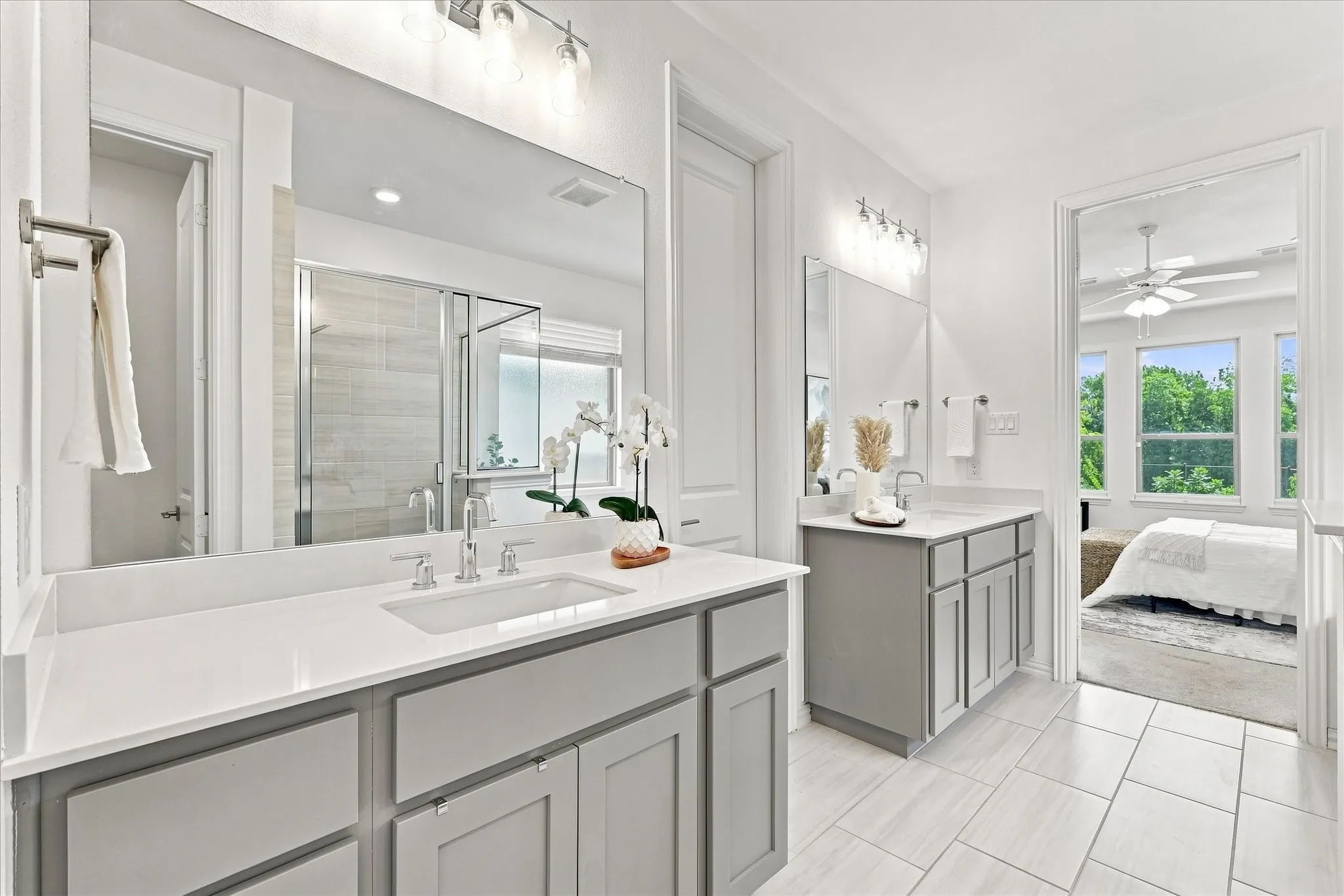 Dual vanity with light gray cabinetry and white countertops