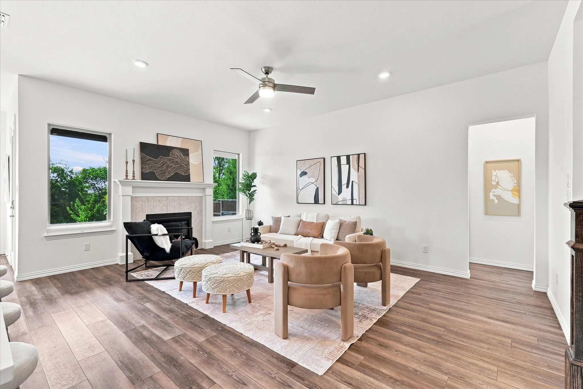 Spacious living area featuring wood-finish flooring, a fireplace with a stone surround and mantel, recessed lighting, and a ceiling fan