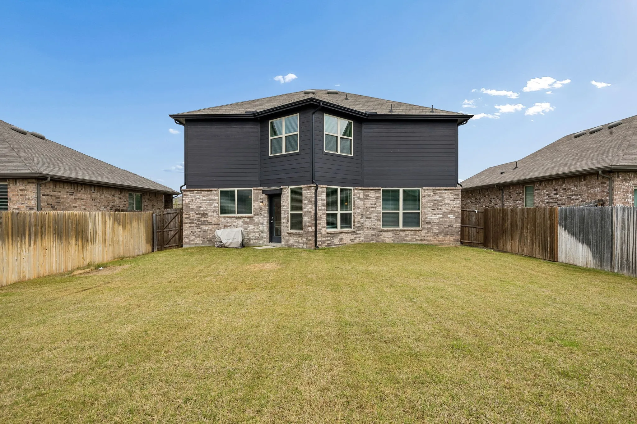 Fenced backyard offers plenty of usable lawn for outdoor living.