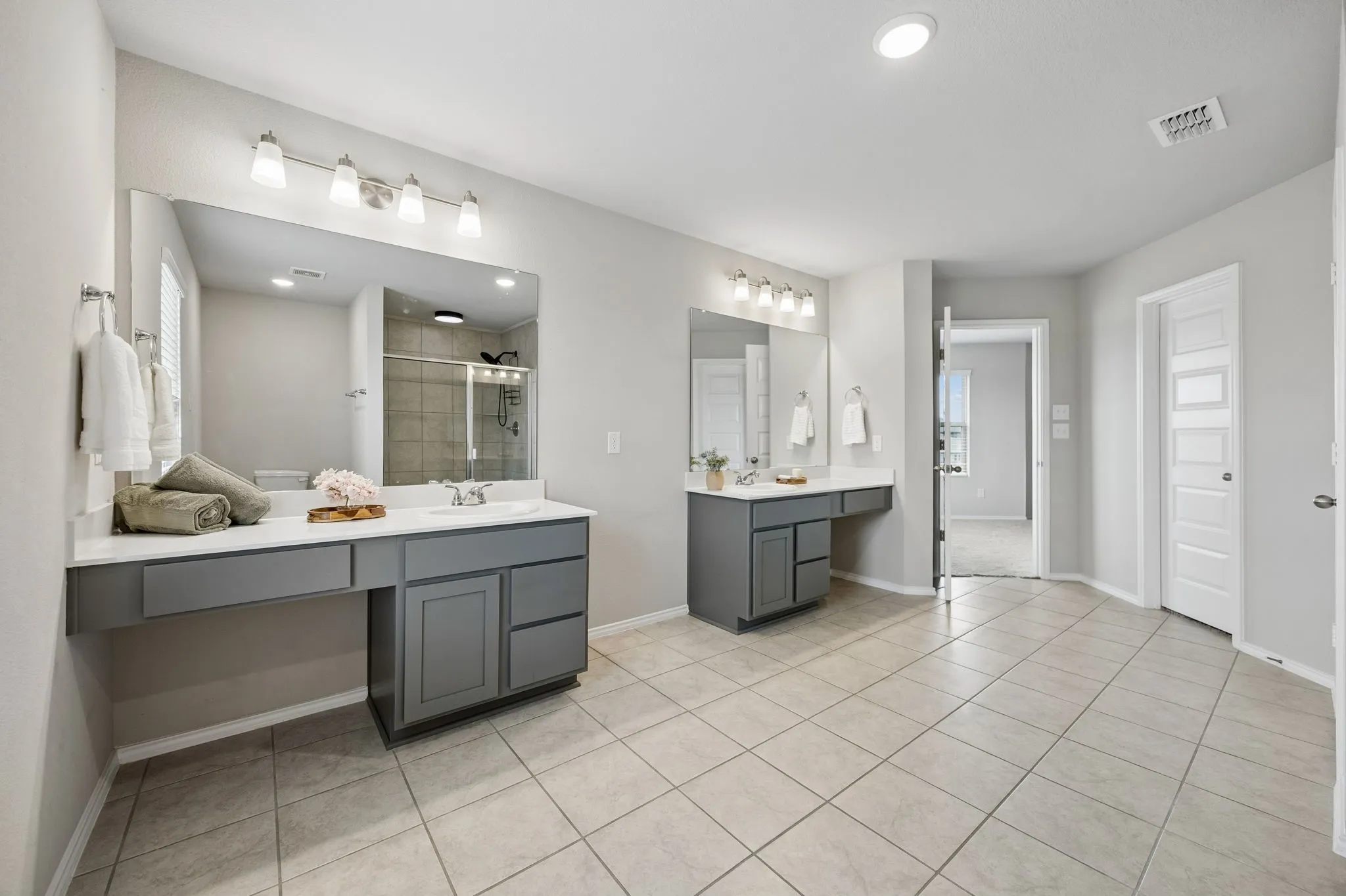 Dual vanities provide separate prep space in the primary bath.