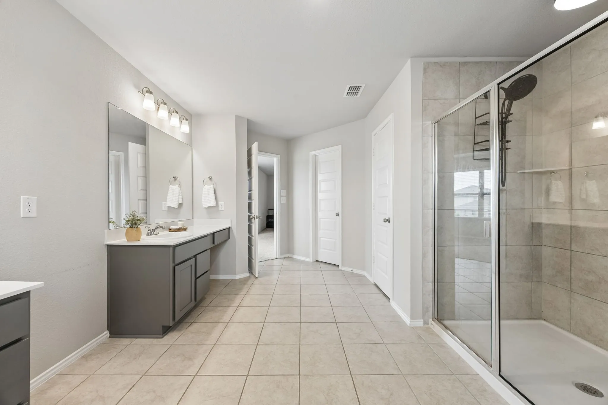 Spacious primary bath with oversized shower, generous vanity space and excellent storage.