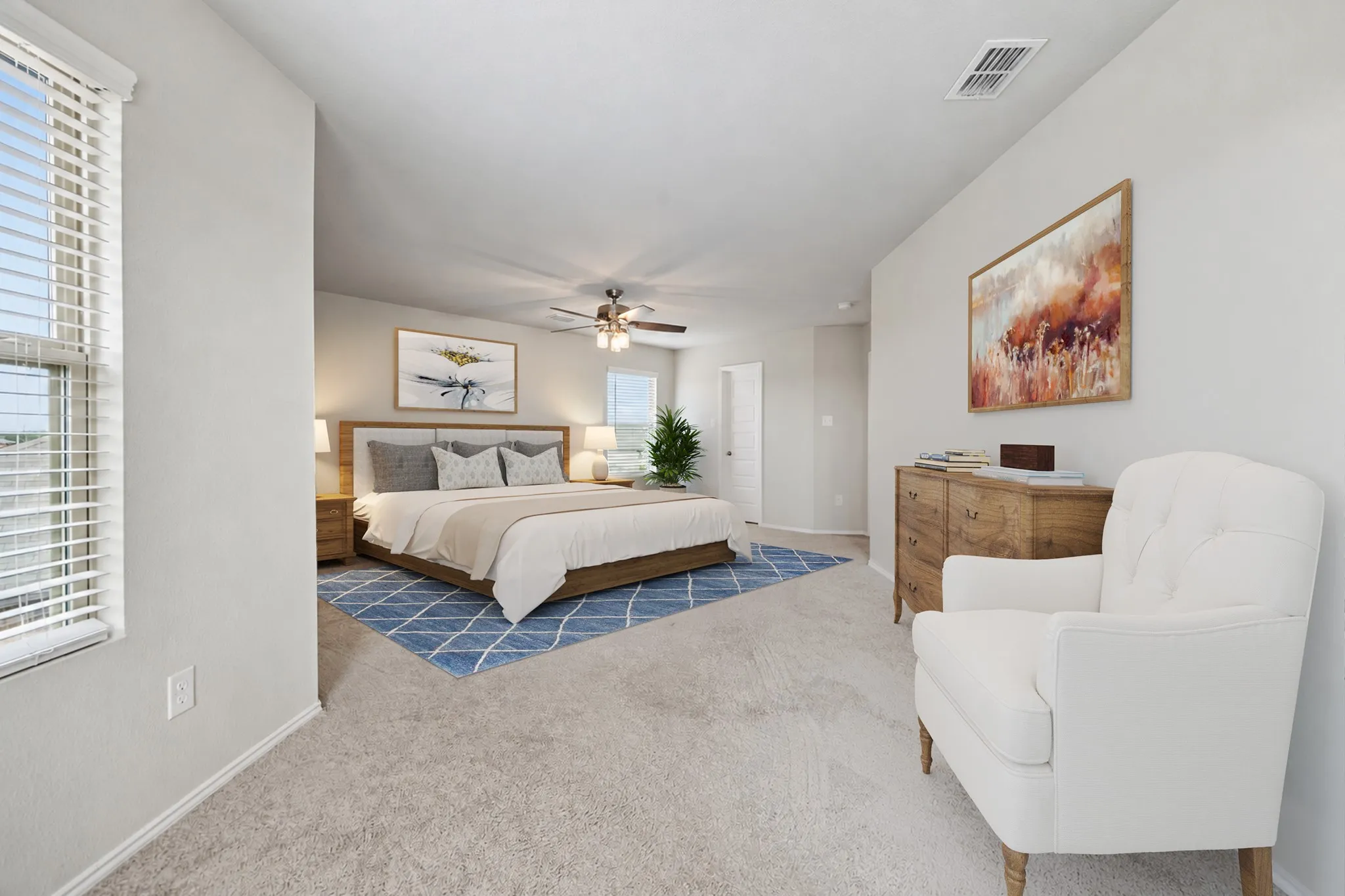 Multiple windows bring natural light into the spacious primary bedroom and sitting area.