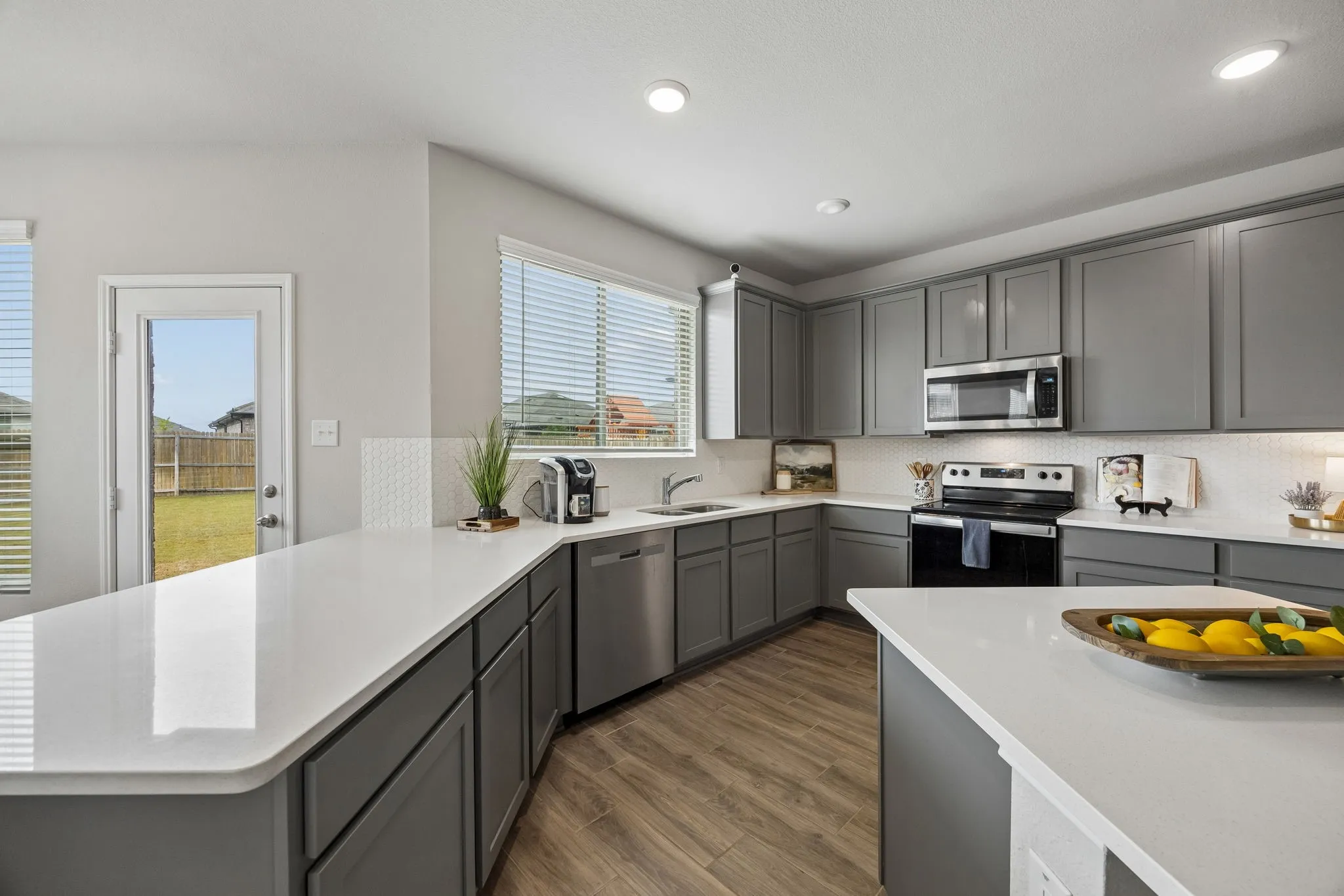 Spacious kitchen with quartz counters, a large island, abundant cabinetry and generous prep space.