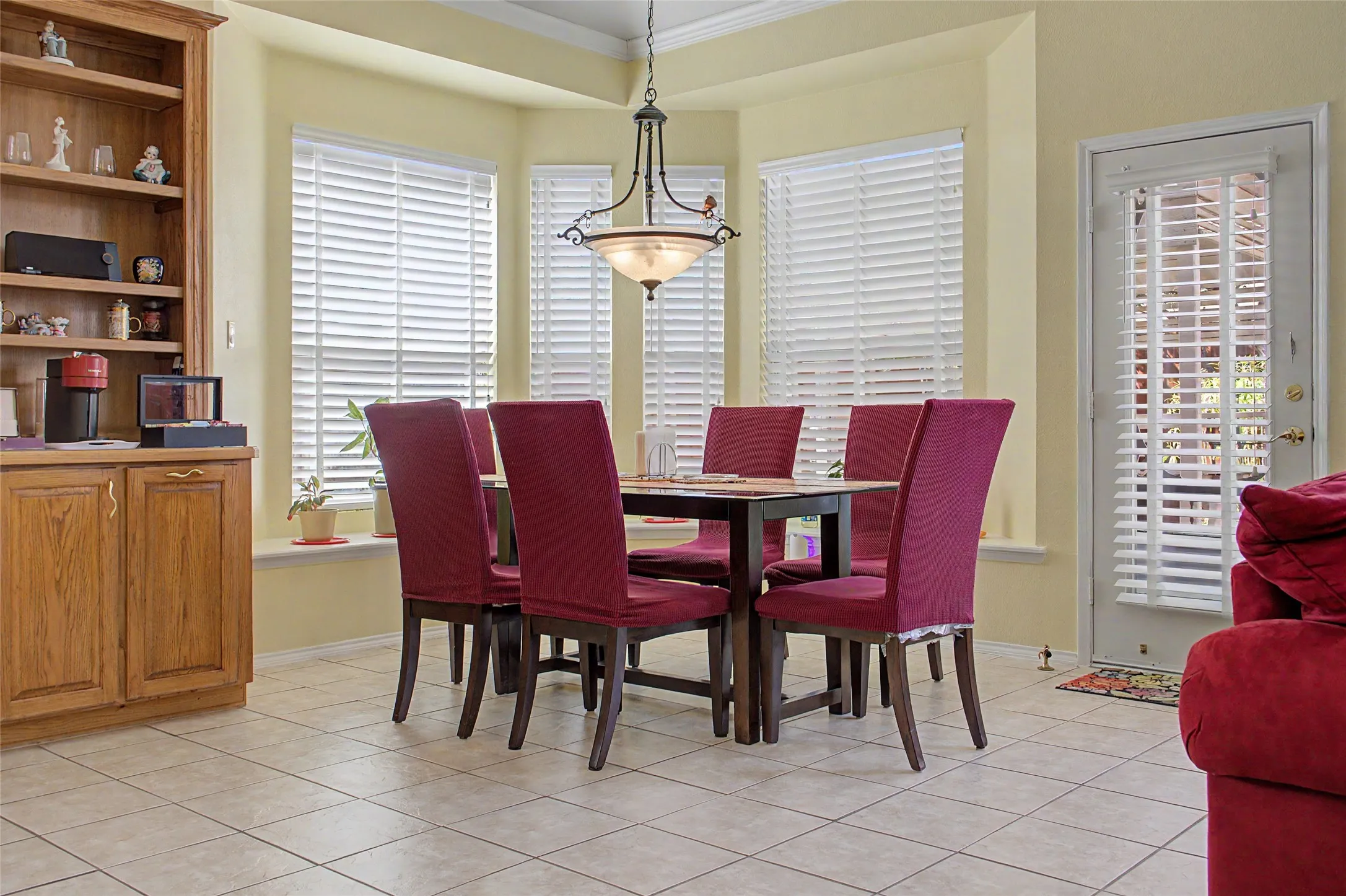Bay windows, built-in shelving, tile flooring, built-in cabinetry, and a ceiling-mounted light fixture