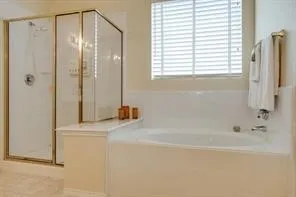 Built-in soaking tub, glass-enclosed shower, and window with horizontal blinds