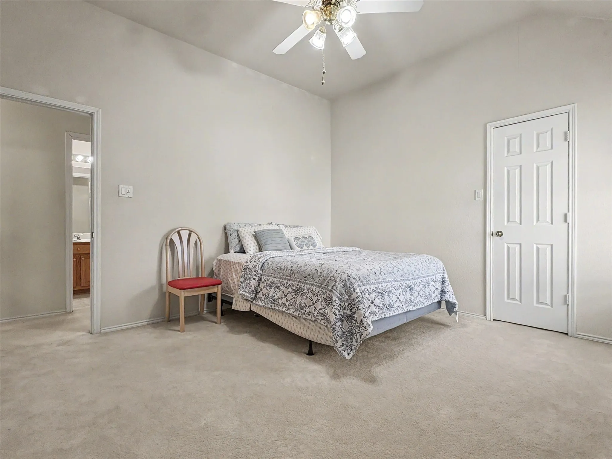 Carpeted room featuring a vaulted ceiling and a ceiling fan with integrated lighting