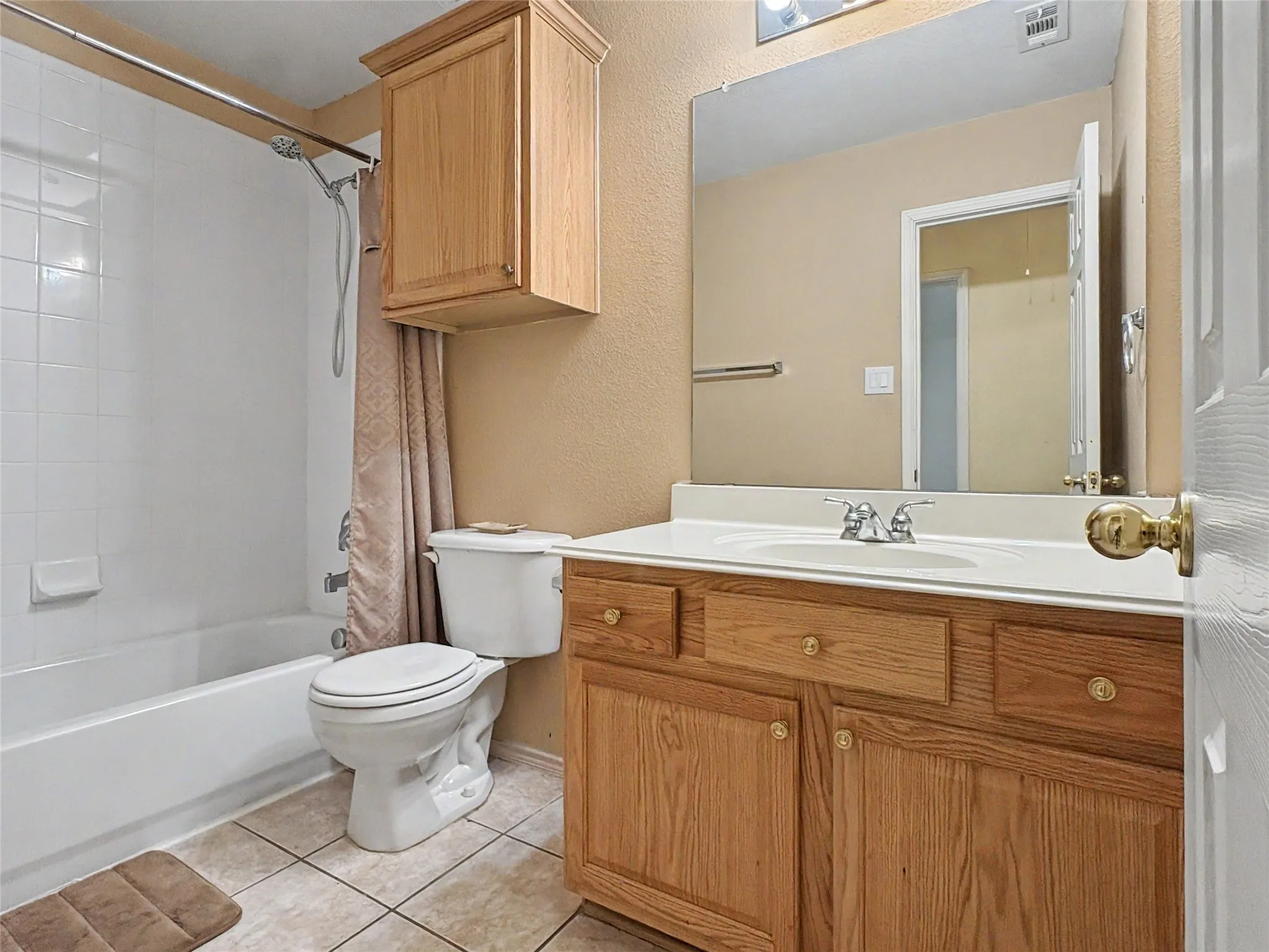 Bathroom featuring a vanity with wood-finish cabinetry, a white countertop, and an integrated sink
