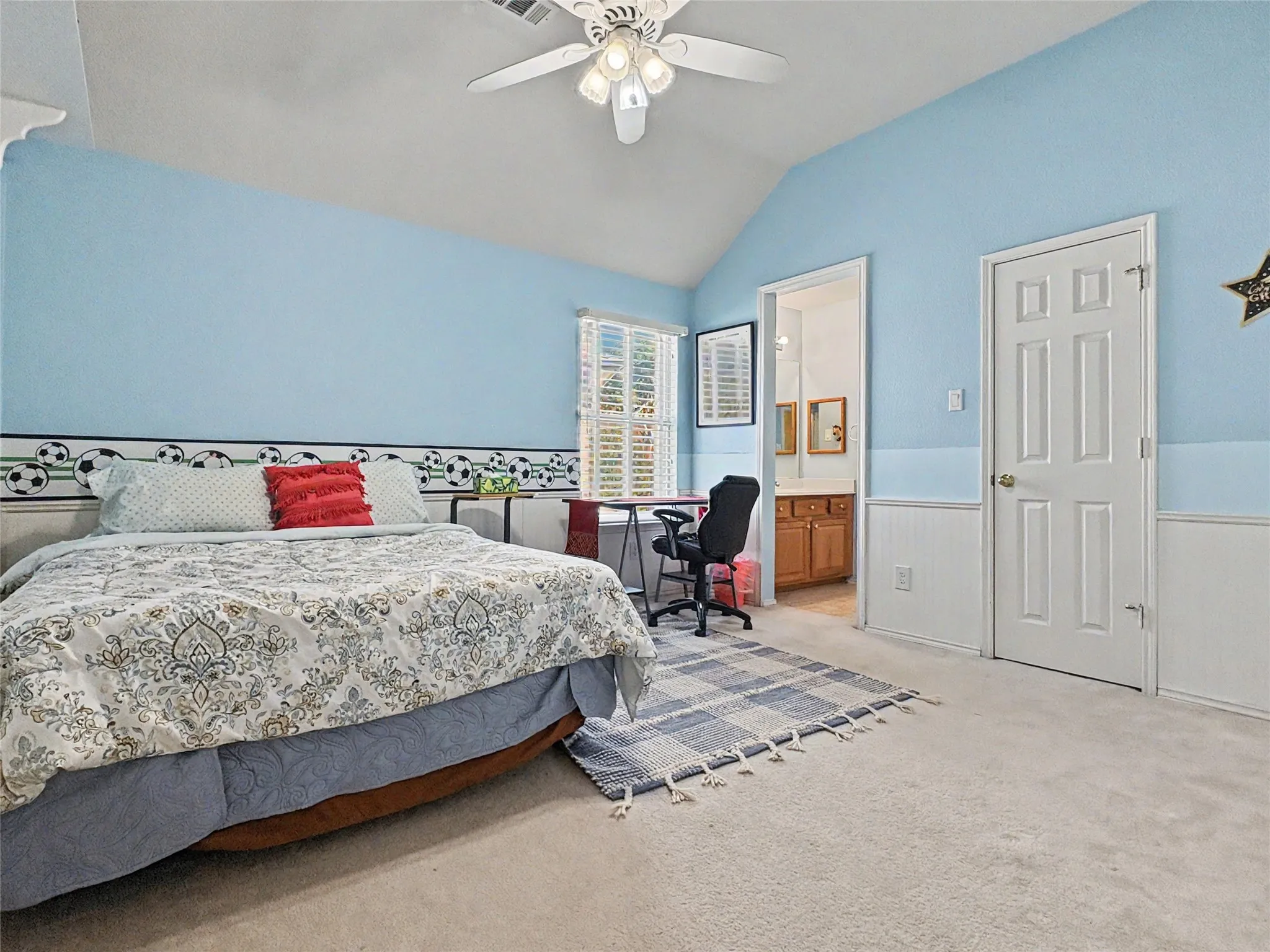 Vaulted ceiling with a ceiling fan, white paneled door, and white plantation shutters