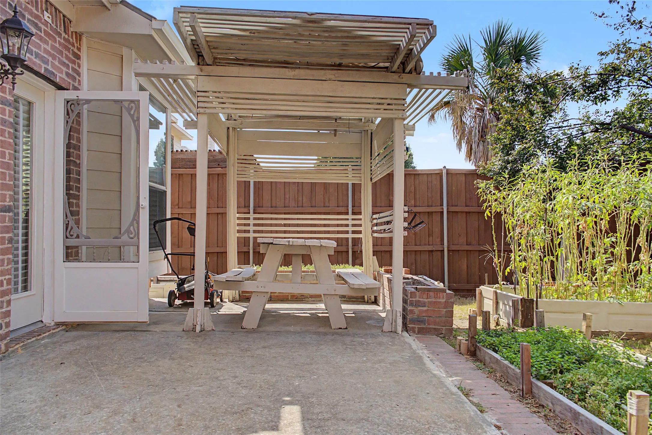 Paved patio area featuring a wooden pergola