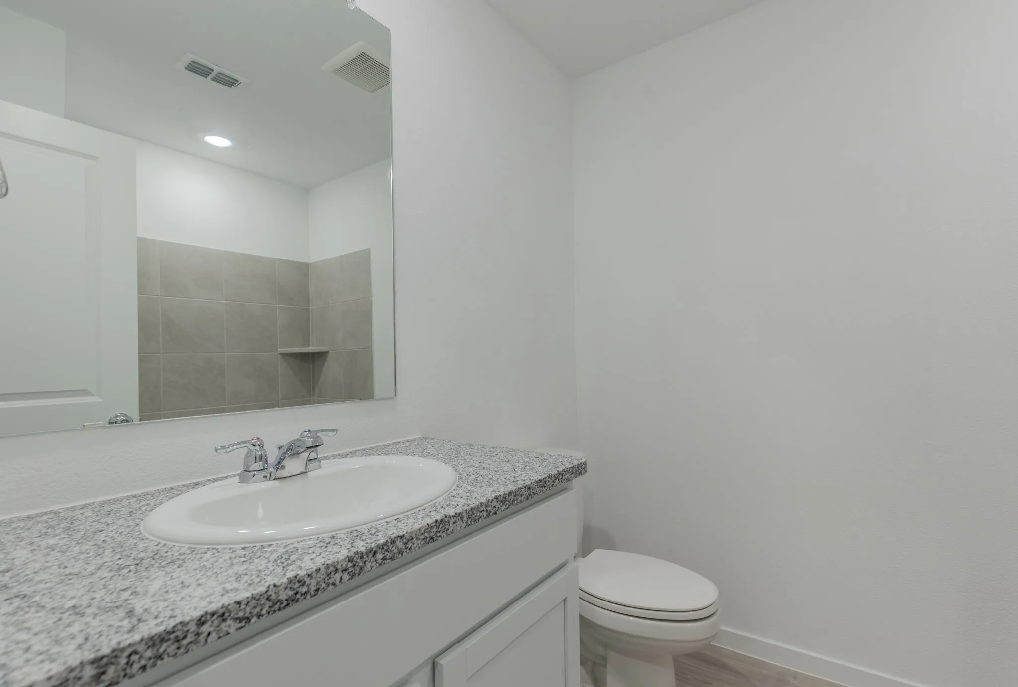 Bathroom featuring wood-type flooring, vanity, and toilet