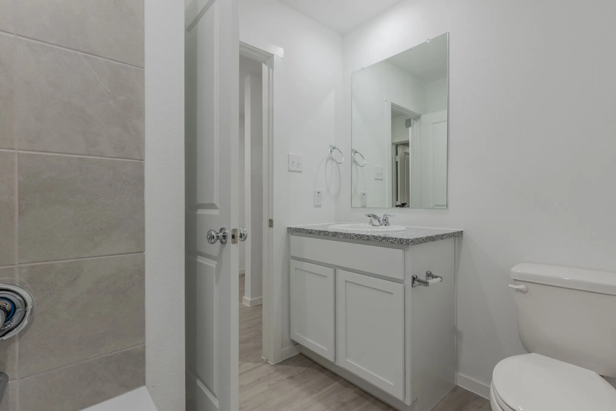 Bathroom featuring vanity, toilet, and wood-type flooring