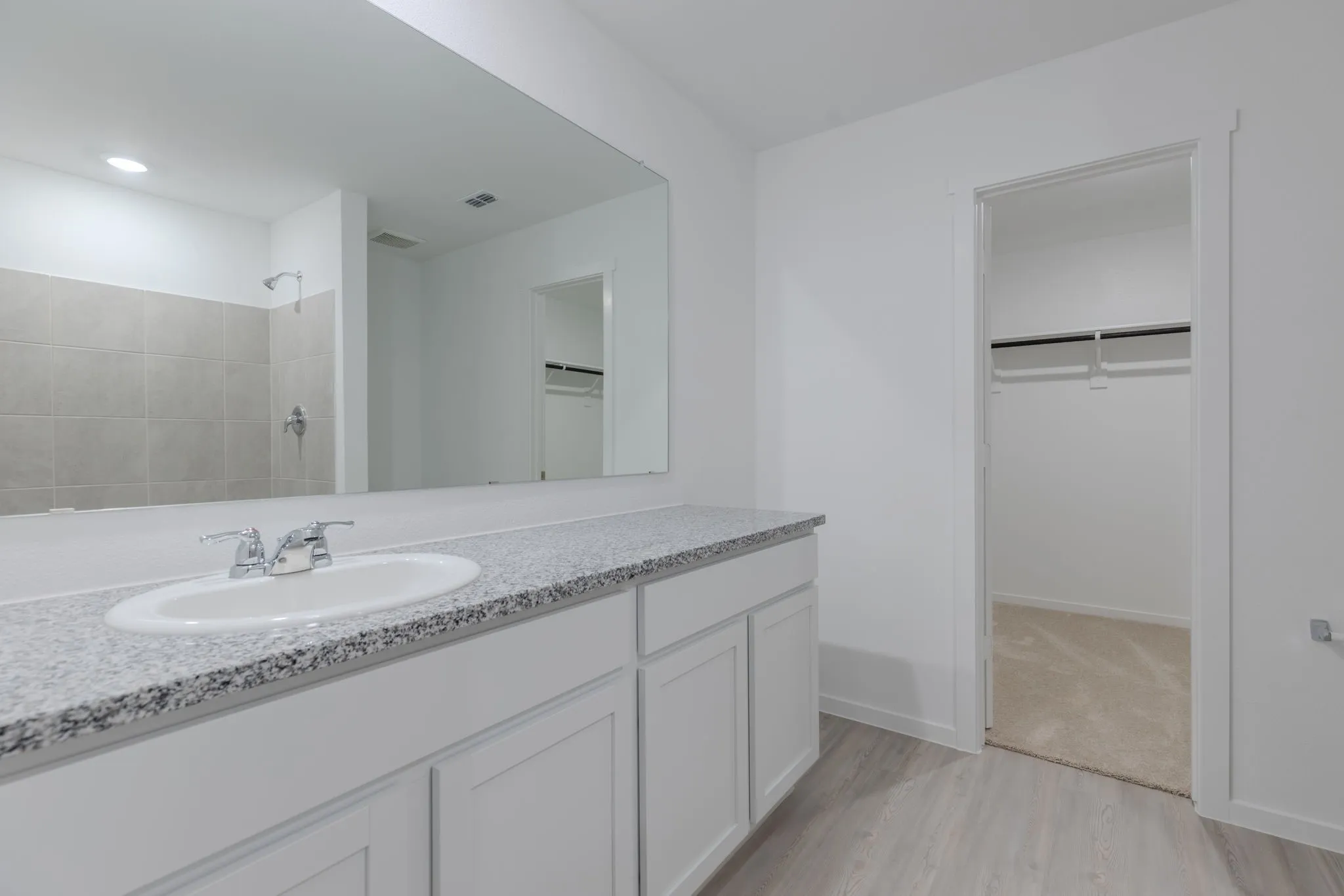Bathroom featuring hardwood / wood-style floors, vanity, and walk in shower