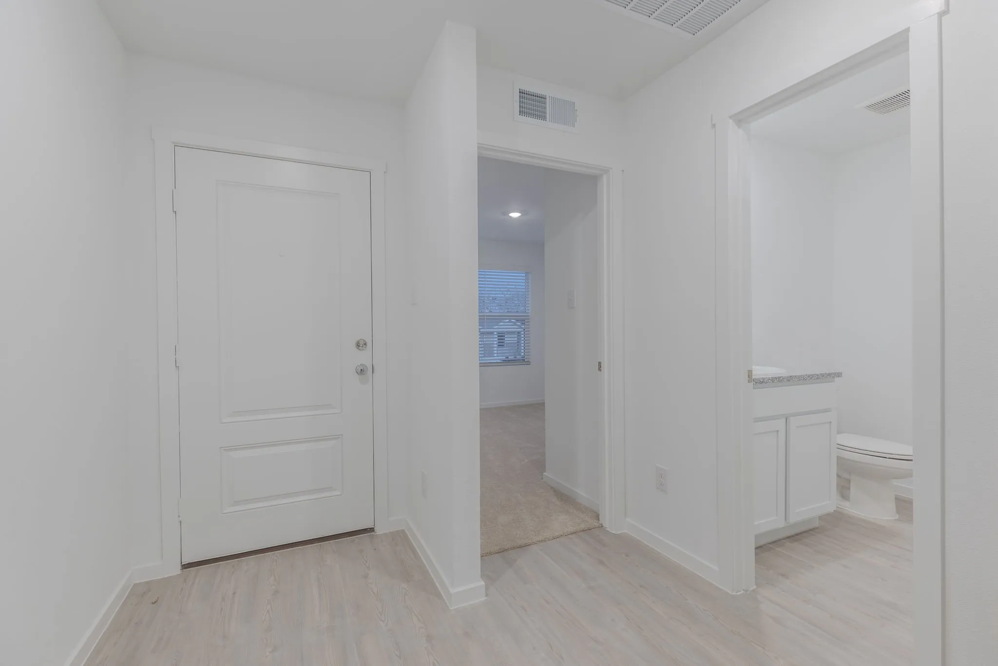 Corridor with light hardwood / wood-style flooring