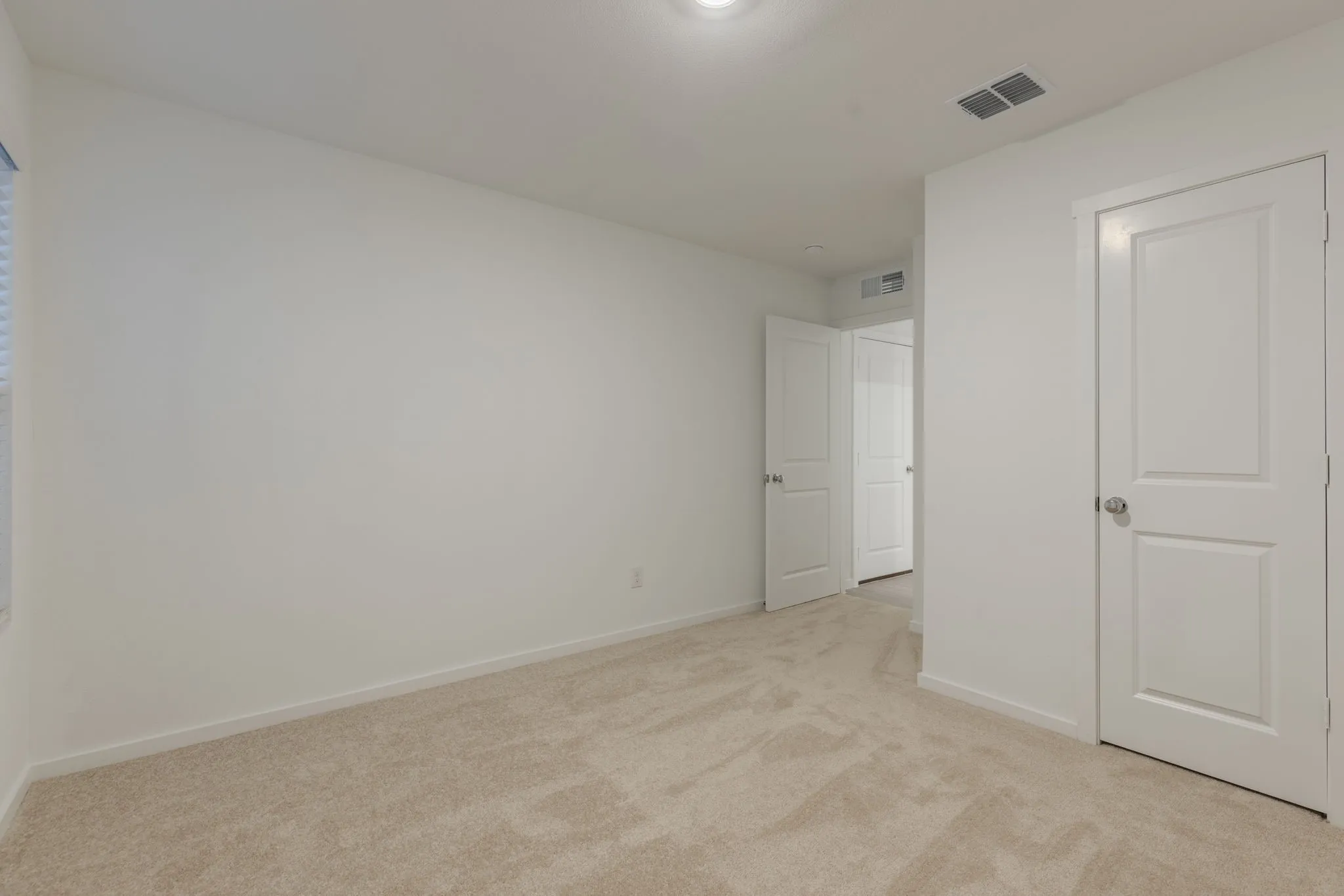 Unfurnished bedroom with light colored carpet