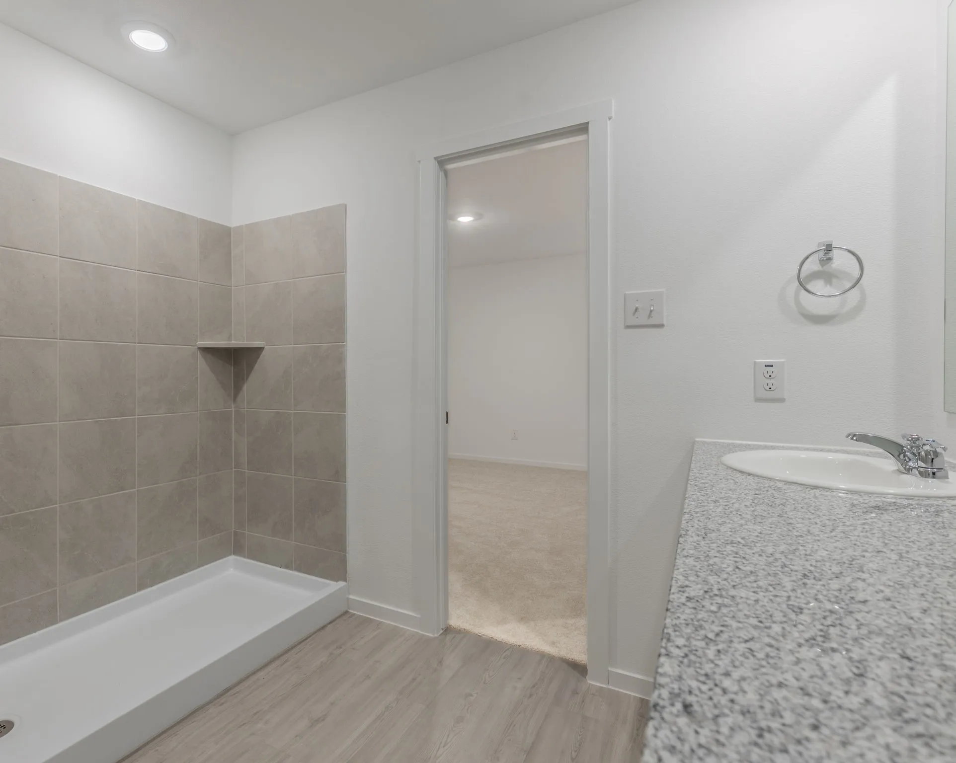 Bathroom featuring hardwood / wood-style flooring, vanity, and a shower
