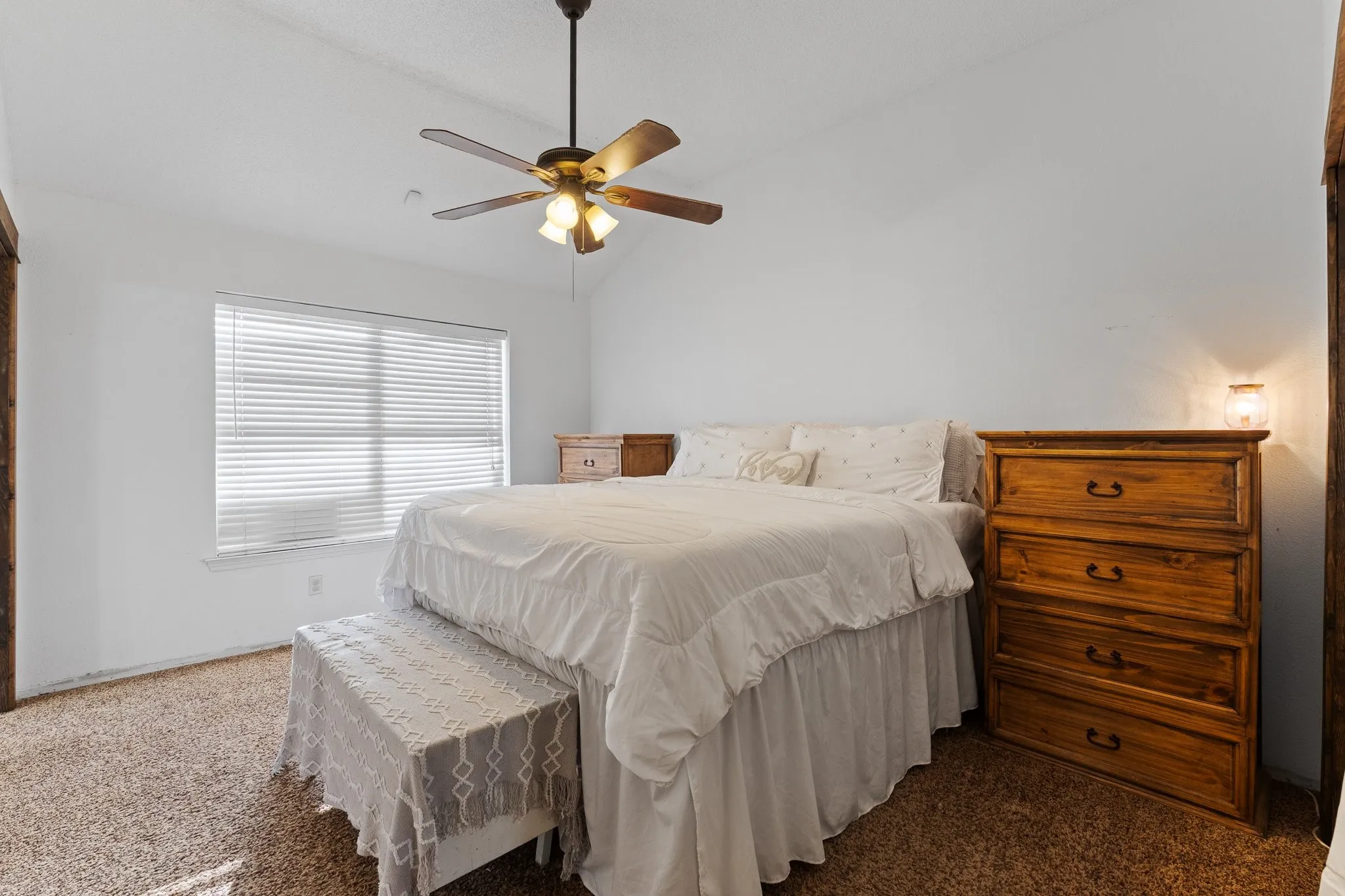 Vaulted ceiling, ceiling fan with integrated lighting, window with blinds, and carpeted flooring