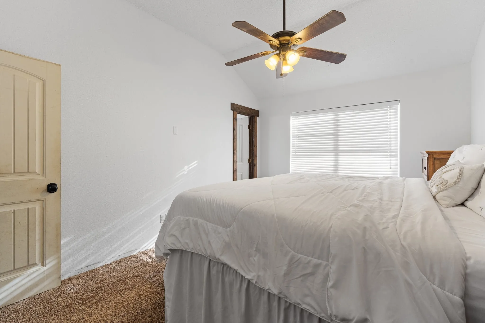 Recessed window with horizontal blinds, sloped ceiling, and a ceiling fan with integrated lighting