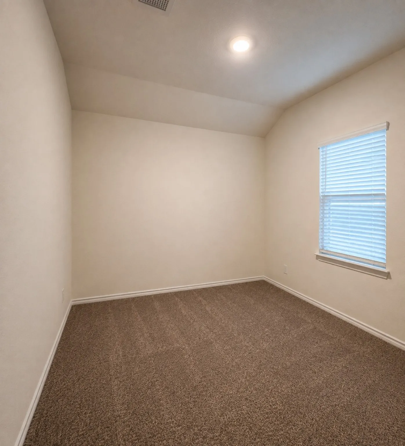 Recessed ceiling lighting, textured wall finish, and brown carpet flooring