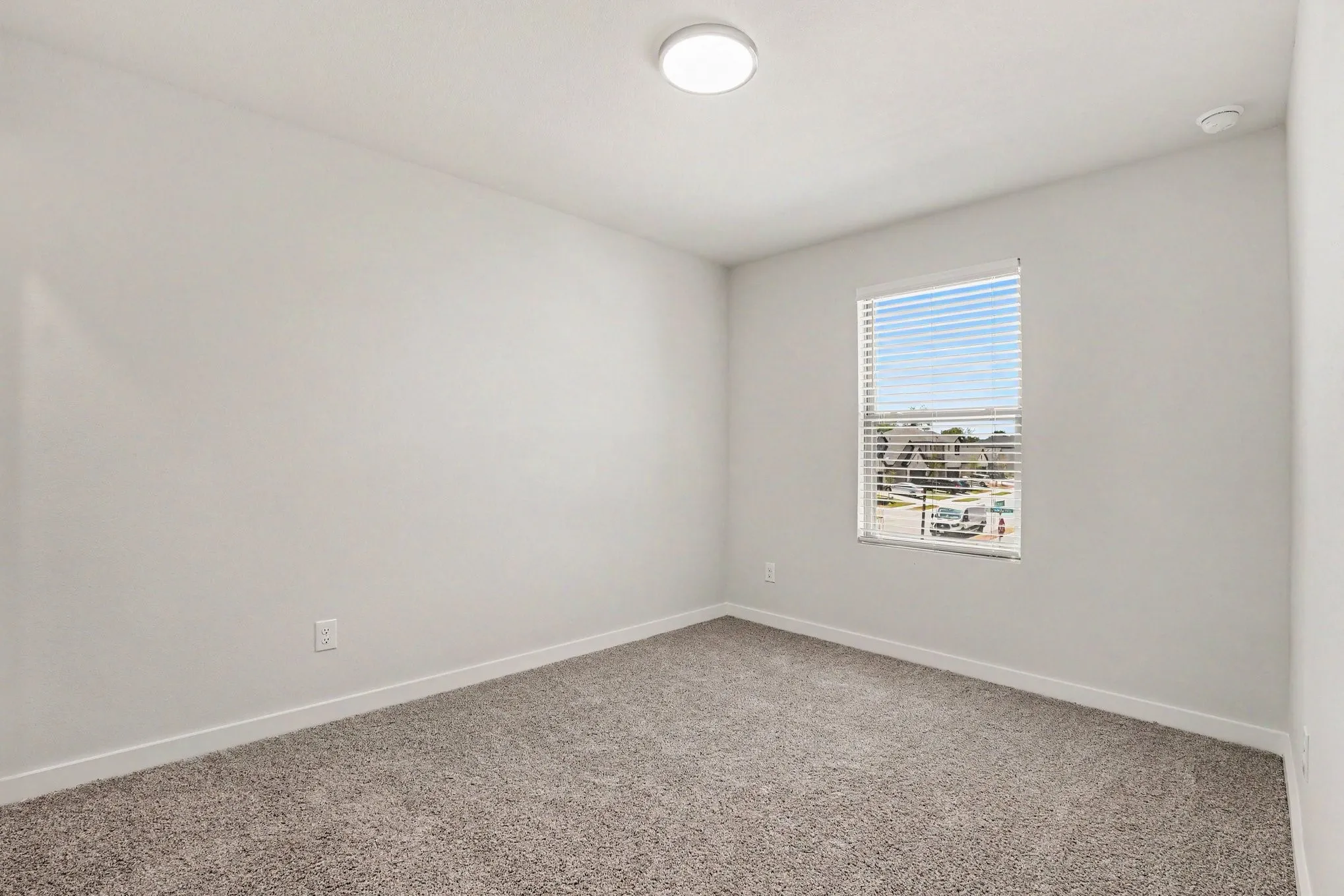 Recessed lighting, window with horizontal blinds, neutral wall tones, and carpeted flooring