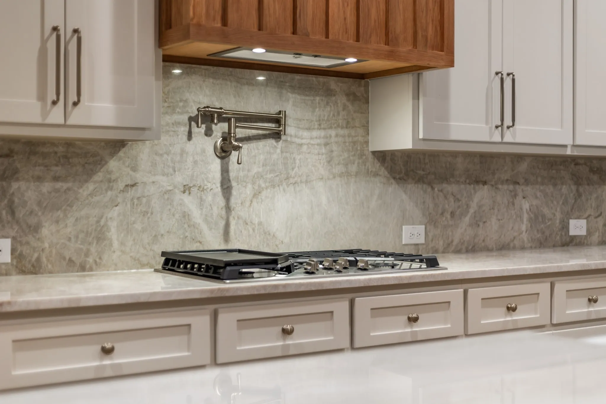 Kitchen with stainless Steel Cooking Center with Pot Filler, light Stone Granite Countertops & tasteful Backsplash!