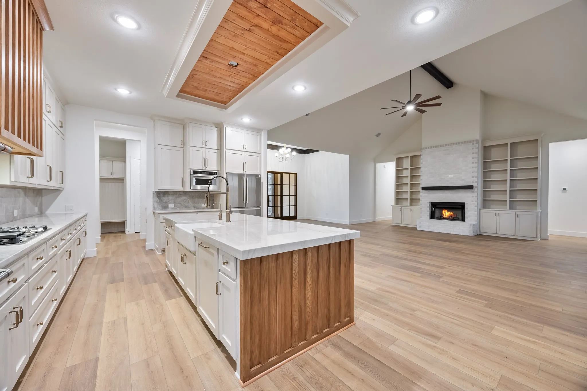 Kitchen featuring warm wood accents, white cabinets with gold pulls, lots of light for cooking and entertaining!