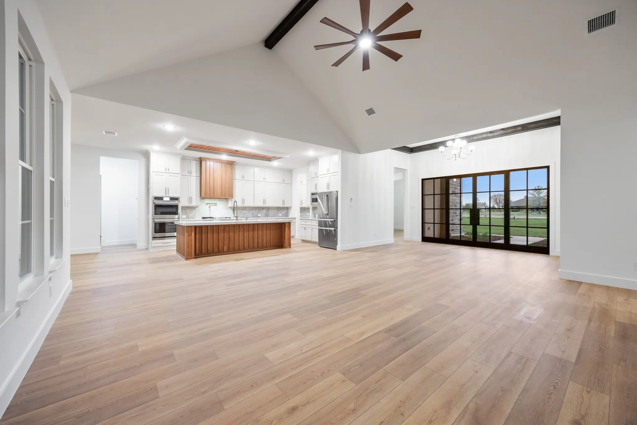 Living Room Open Floorplan for easy entertaining! Kitchen with  Beautiful Island with Light Granite Countertops, light wood finished floors, decorative ceiling!