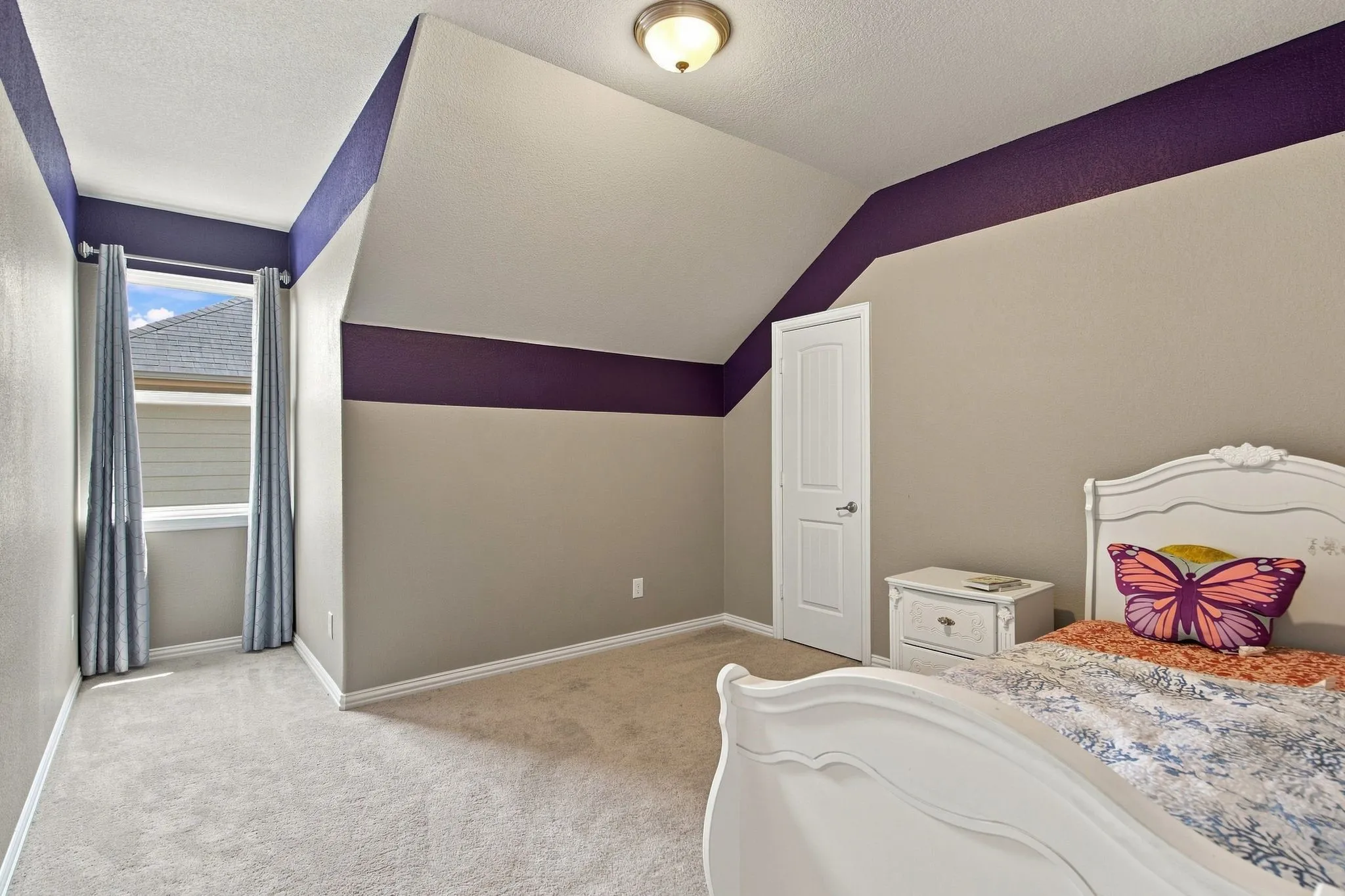 Carpeted flooring, recessed window, white paneled door, ceiling-mounted light fixture, and textured walls