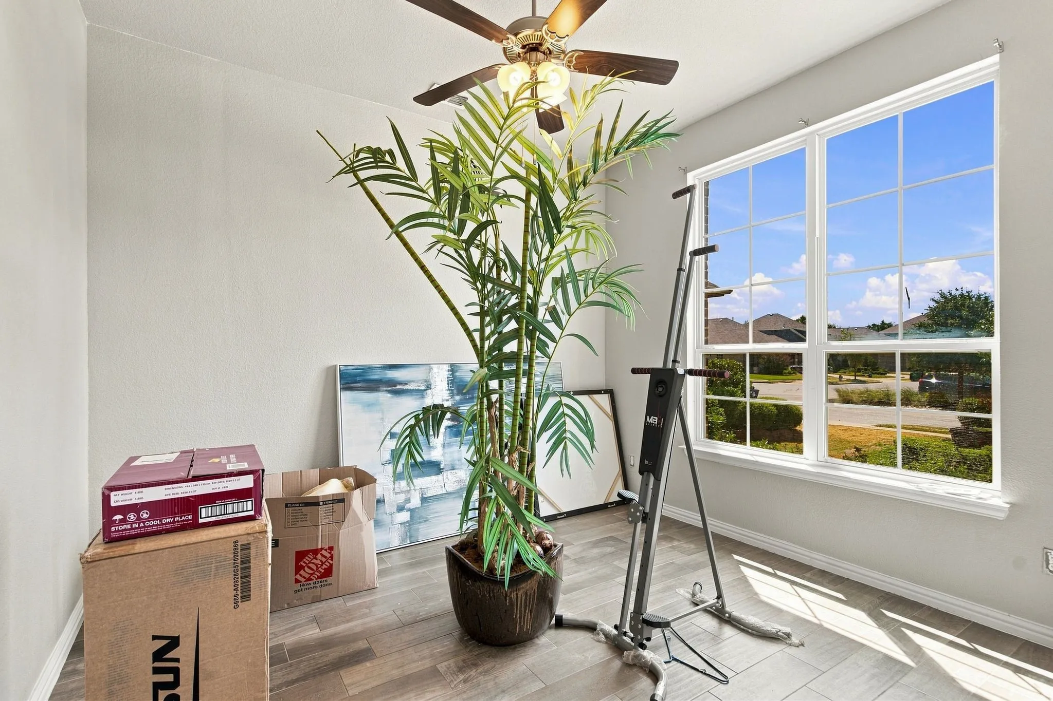 5th Bedroom Large window with multi-pane grid, wood-finish flooring, and ceiling fan with integrated lighting