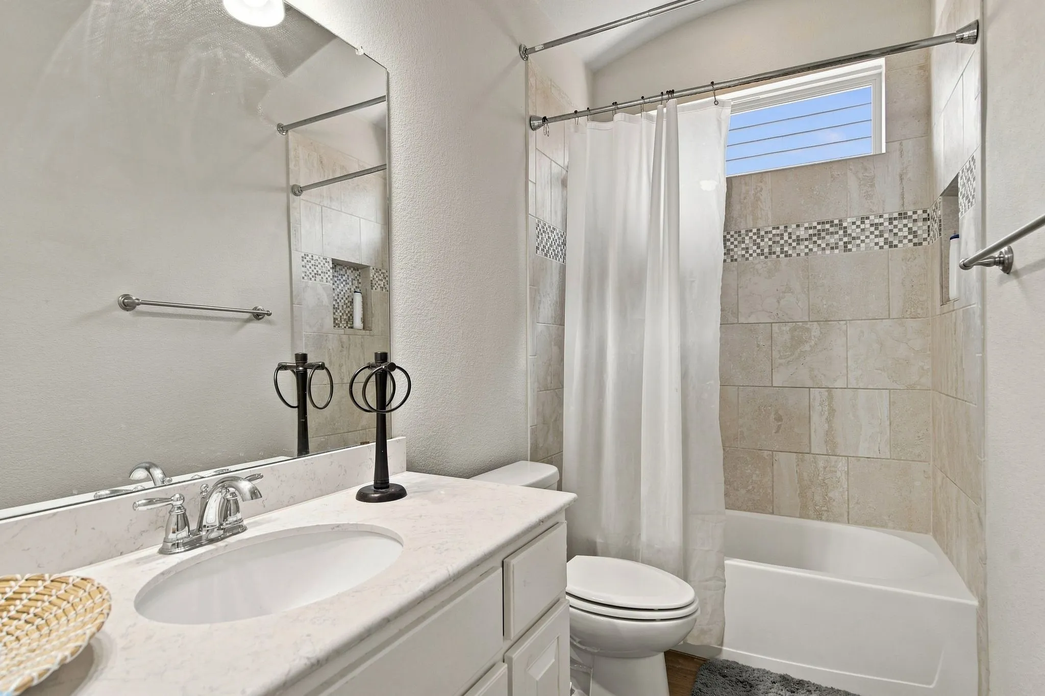 White vanity with an integrated sink, polished chrome faucet, and a large wall-mounted mirror