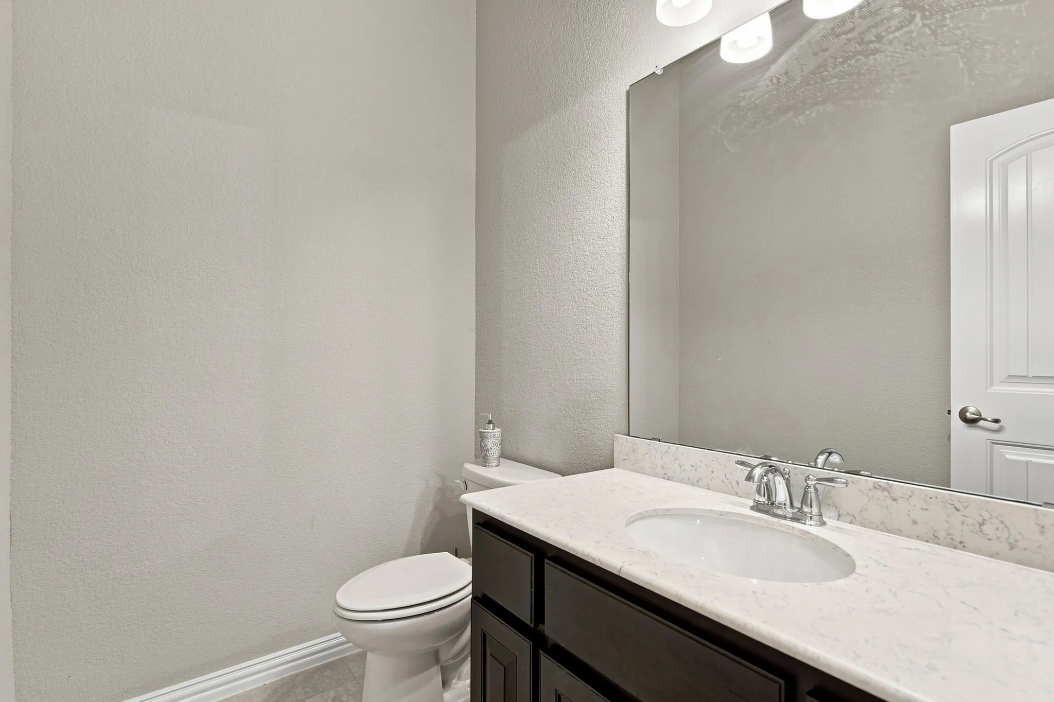 Vanity with a light-toned countertop, undermount sink, and chrome faucet