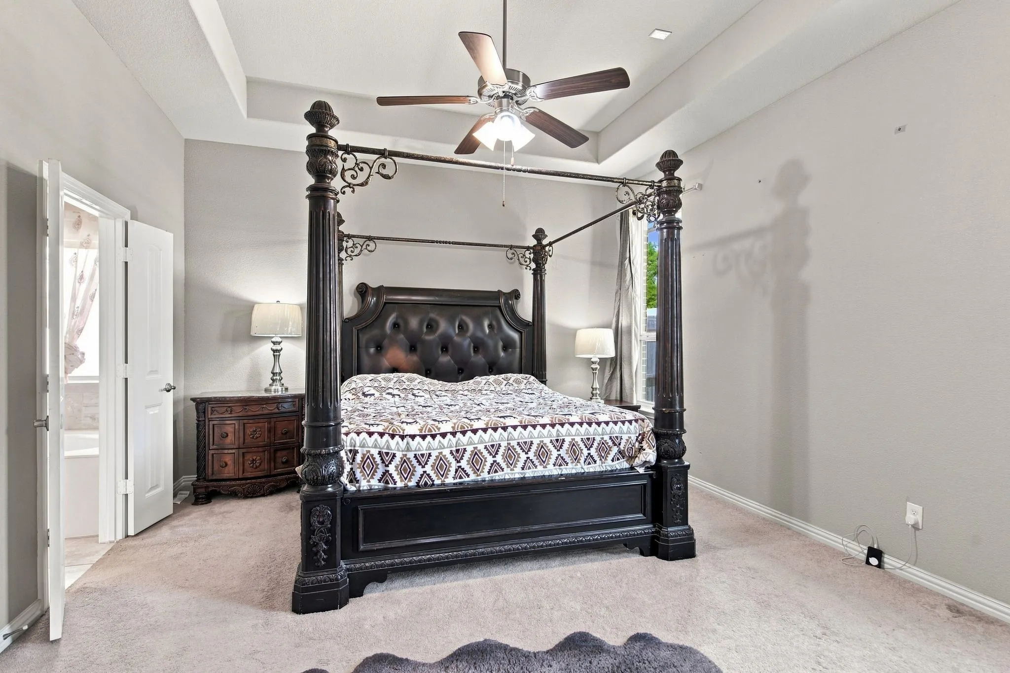Tray ceiling with recessed lighting, ceiling fan, and light-toned wall finishes