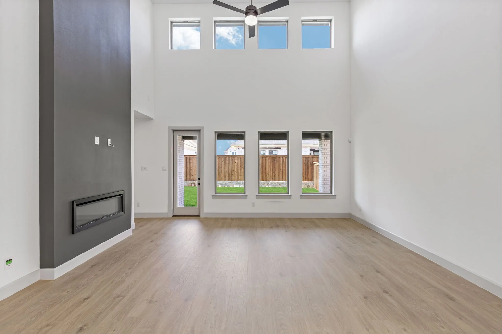 Featuring a striking fireplace and dual stacked wall of windows, this spacious family room is the ideal place to host the entire family!
