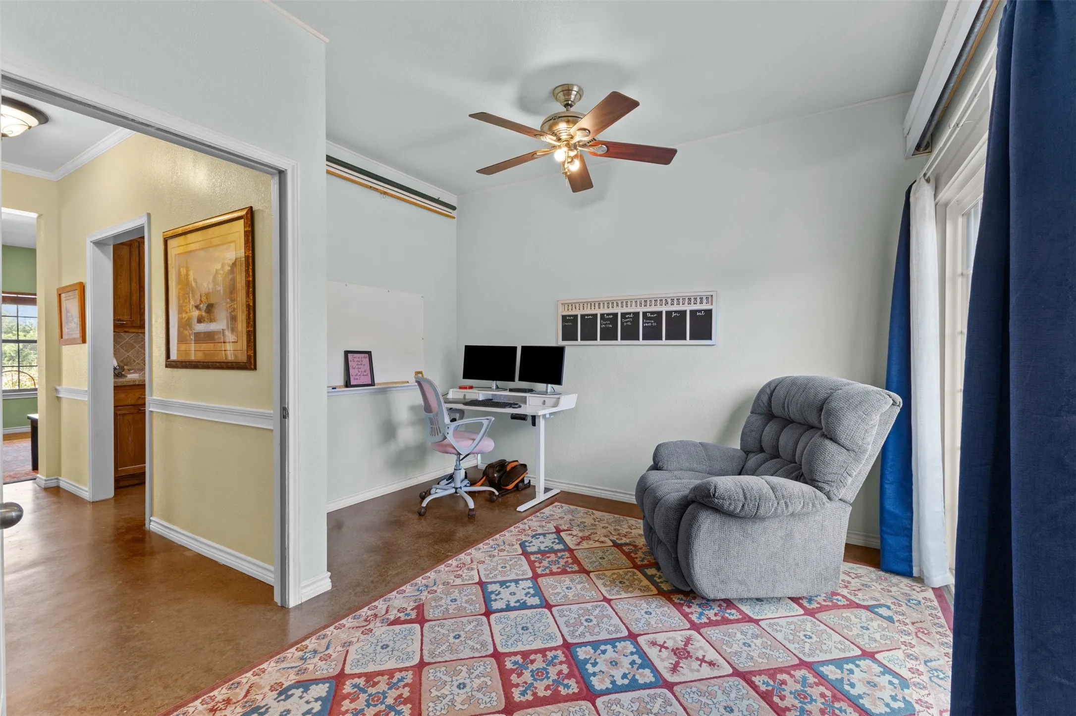 Private office/flex room with built-in desk space, ceiling fan, and a door to the side yard. Works as a home office or a quiet sitting room.