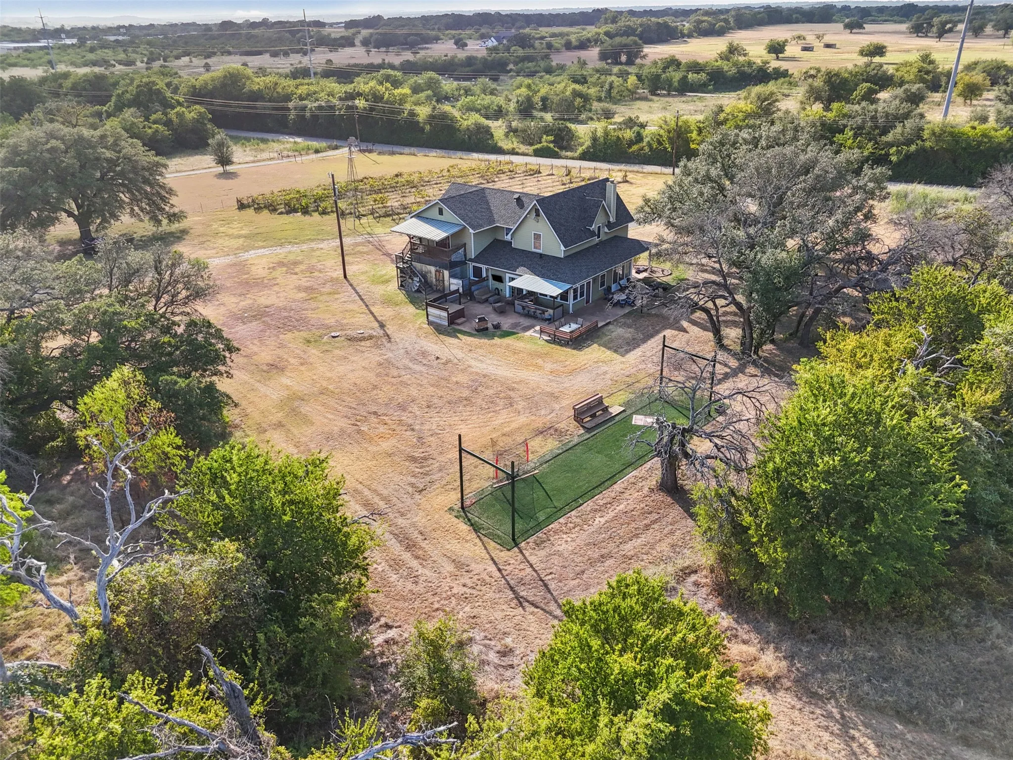 Aerial view of the full 5.529 acre gated, cross-fenced property with a private paved drive. Hood County acreage in Granbury ISD, room to spread out.