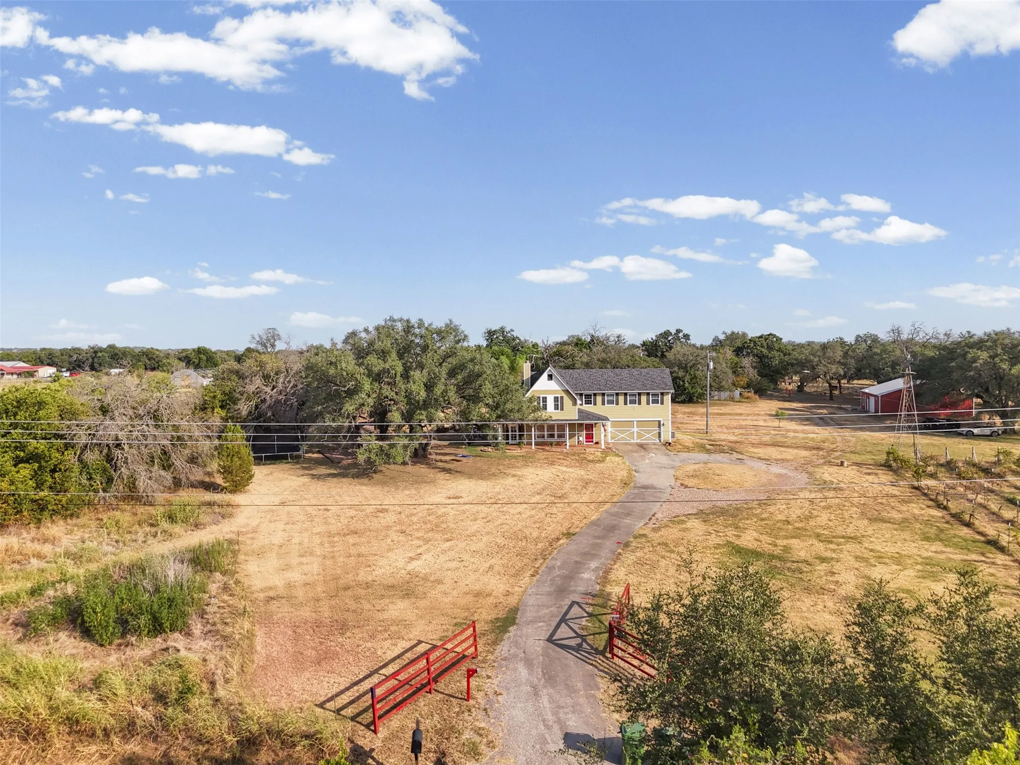 Aerial view of the full 5.529 acre gated, cross-fenced property with a private paved drive. Hood County acreage in Granbury ISD, room to spread out.