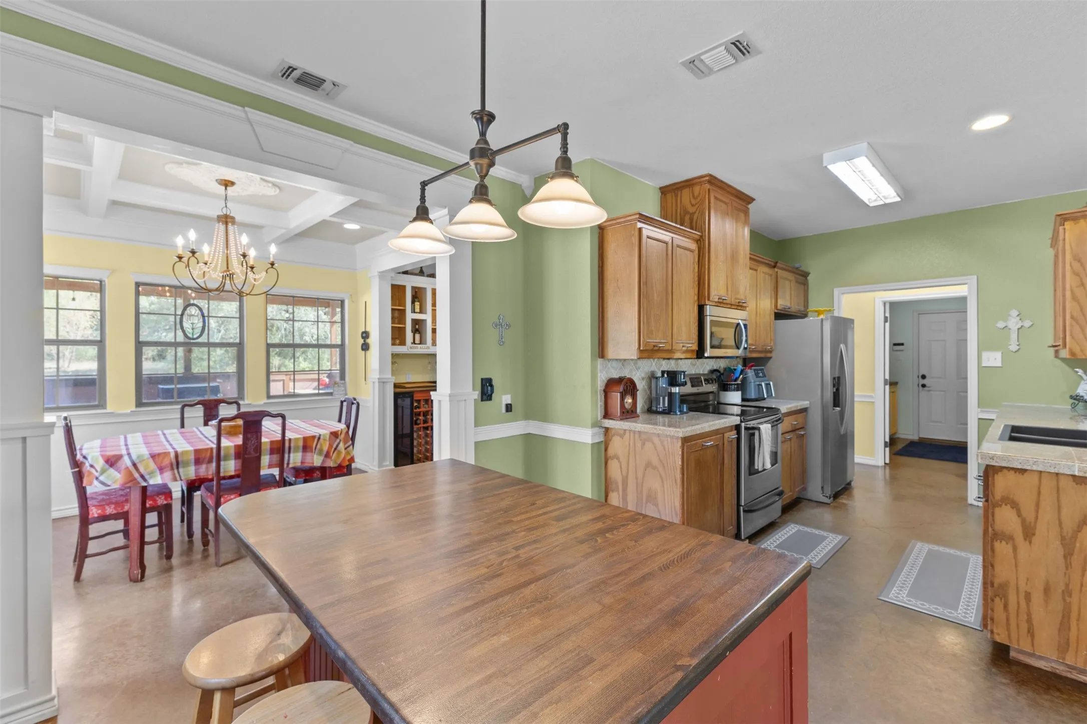 Kitchen featuring wood cabinetry, stainless steel appliances, and a central island with wood countertop