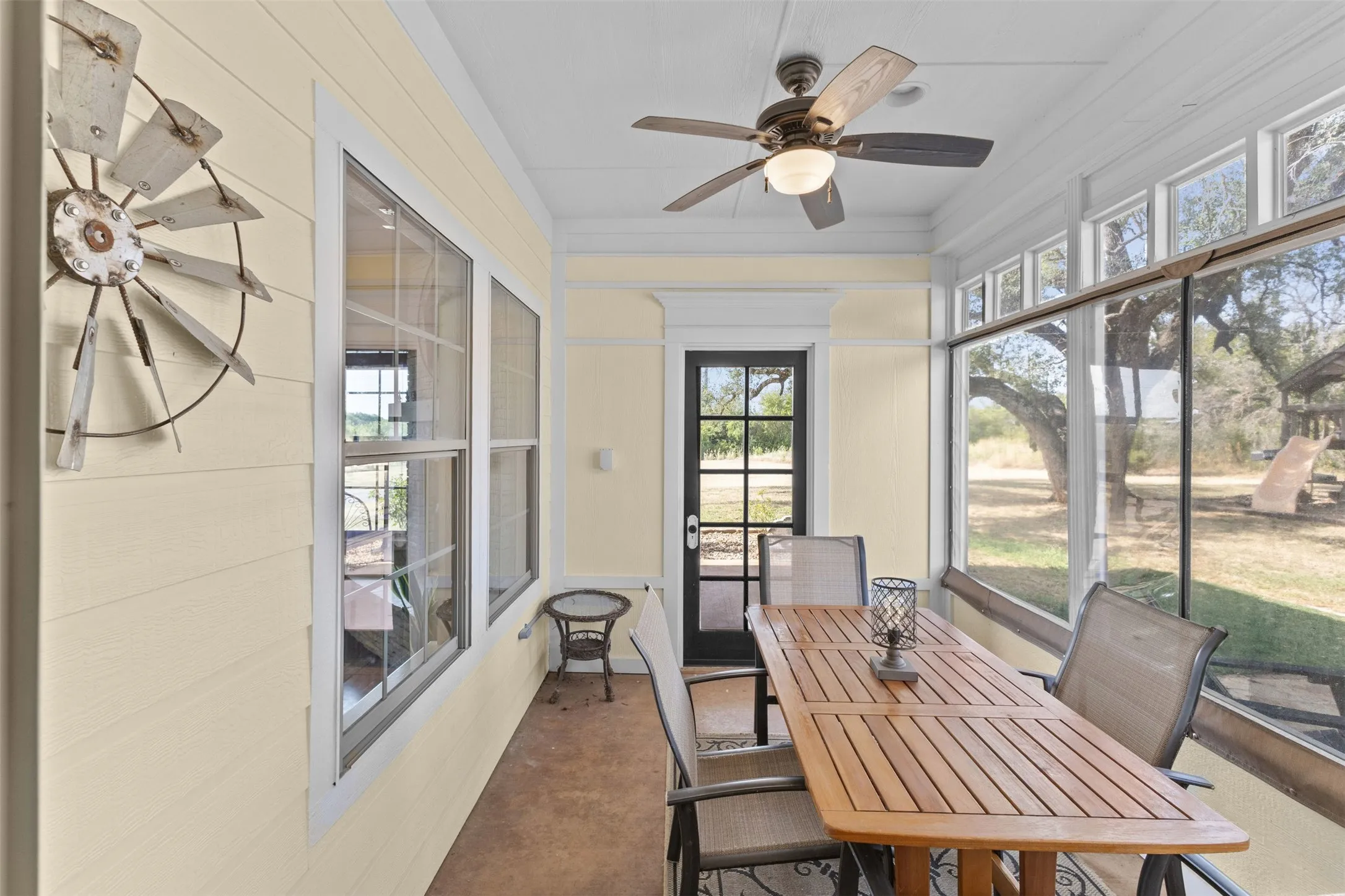 Screened sunroom off the kitchen with a ceiling fan and room for a full dining set, a shaded spot to enjoy the acreage without the bugs or the sun.  Removable Eisenglass for true year-round usability.