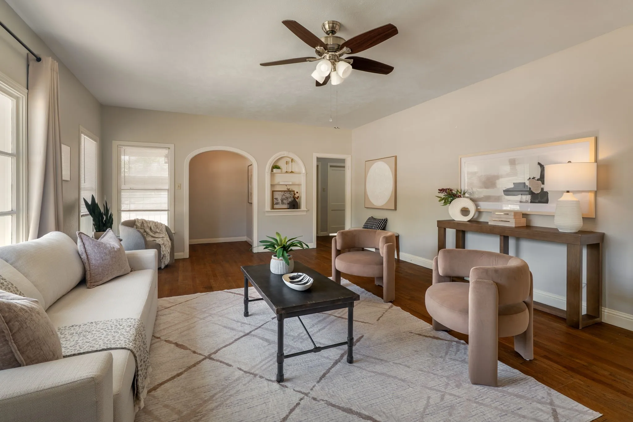 living room with oversized windows, built in shelves, ceiling fan, and open layout to dining area