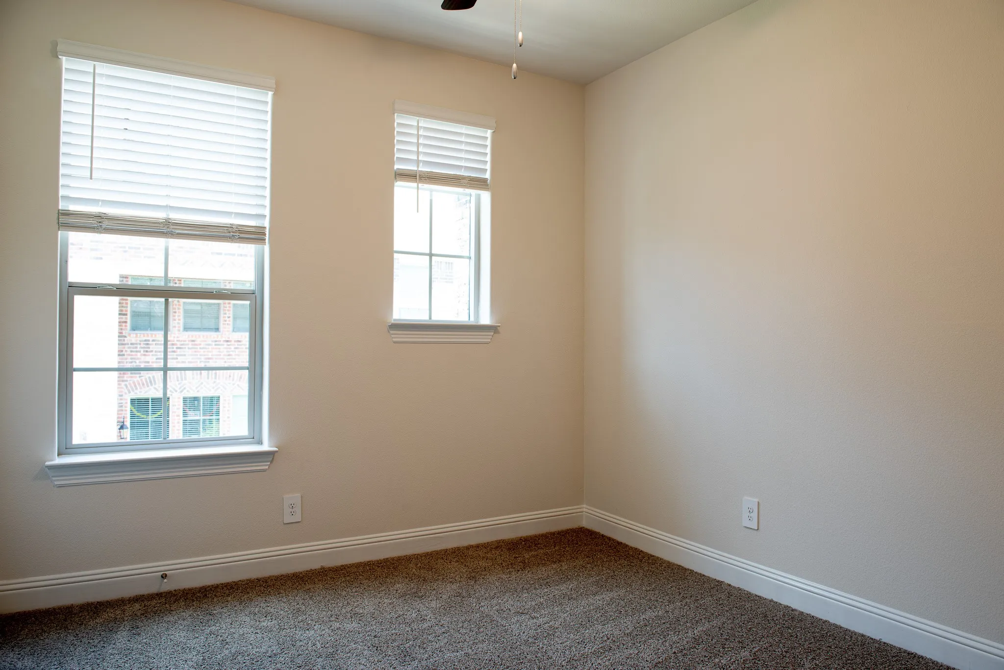 Secondary bedroom with large windows, carpet flooring, and attached spacious closet.